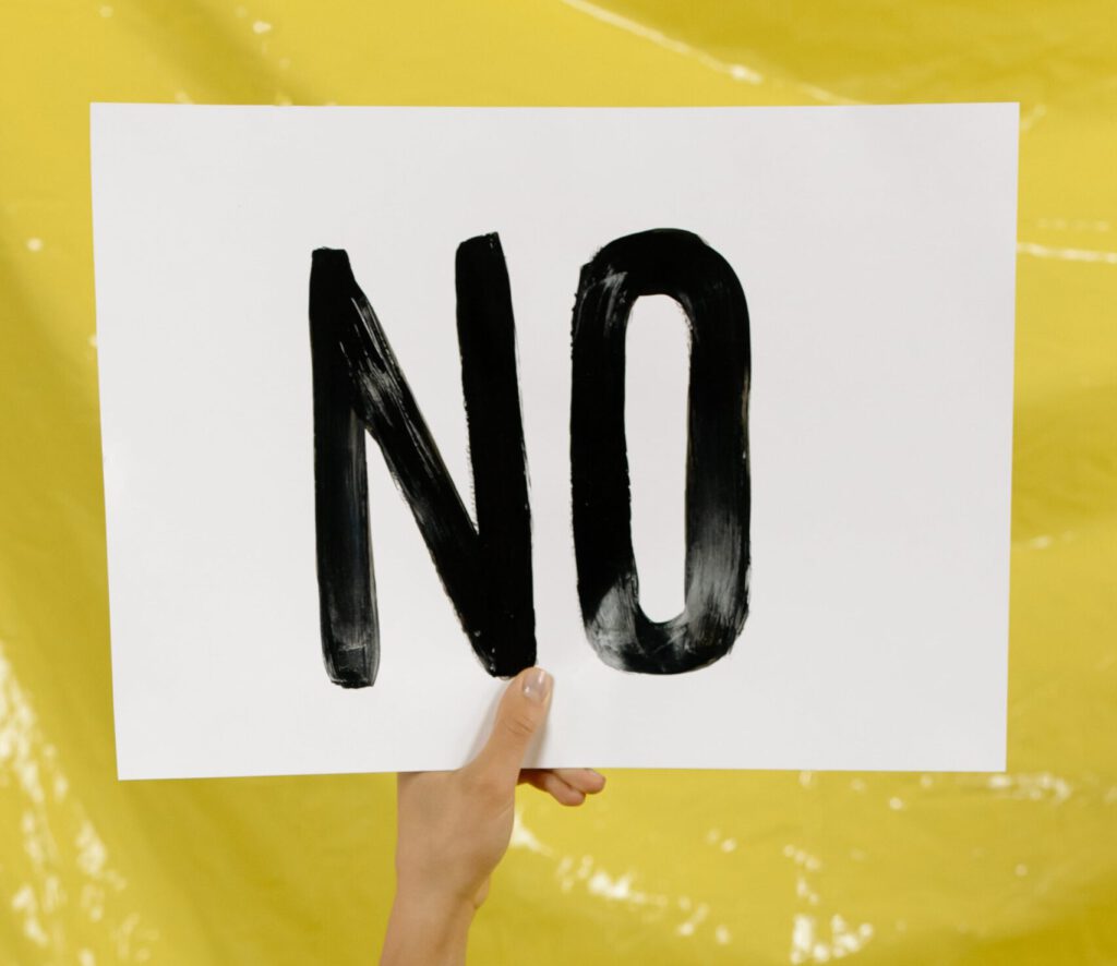 K wie kein Nein. Hand hält ein "No" Plakat
