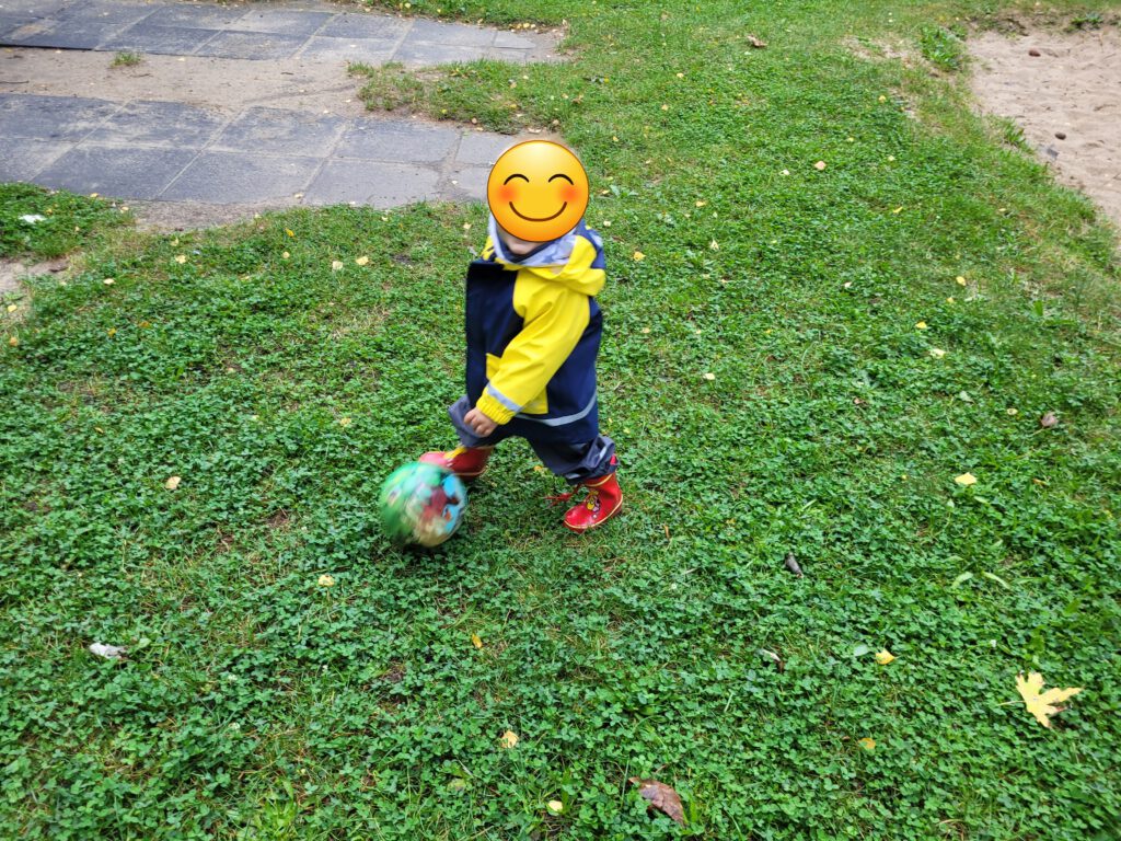 Fußball spielen im Herbst auf dem Spielplatz